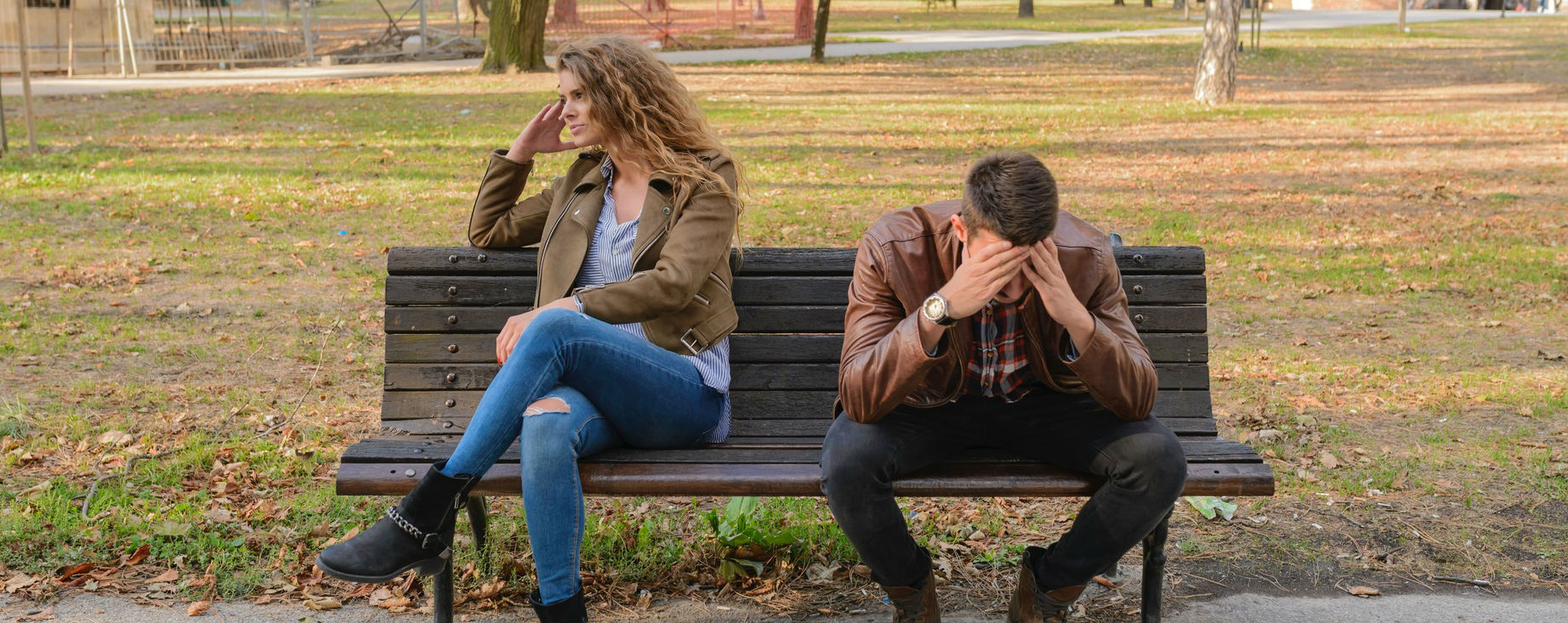 Frustrated man and woman on separated on a park bench