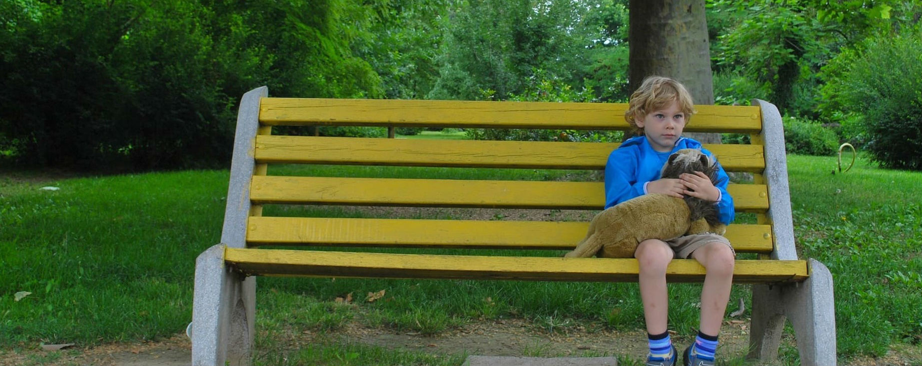 Lonely looking child on a park bench